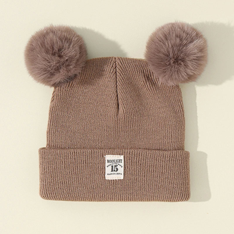 BORA kids pom pom hat in brown with fuzzy pom poms on top for winter warmth