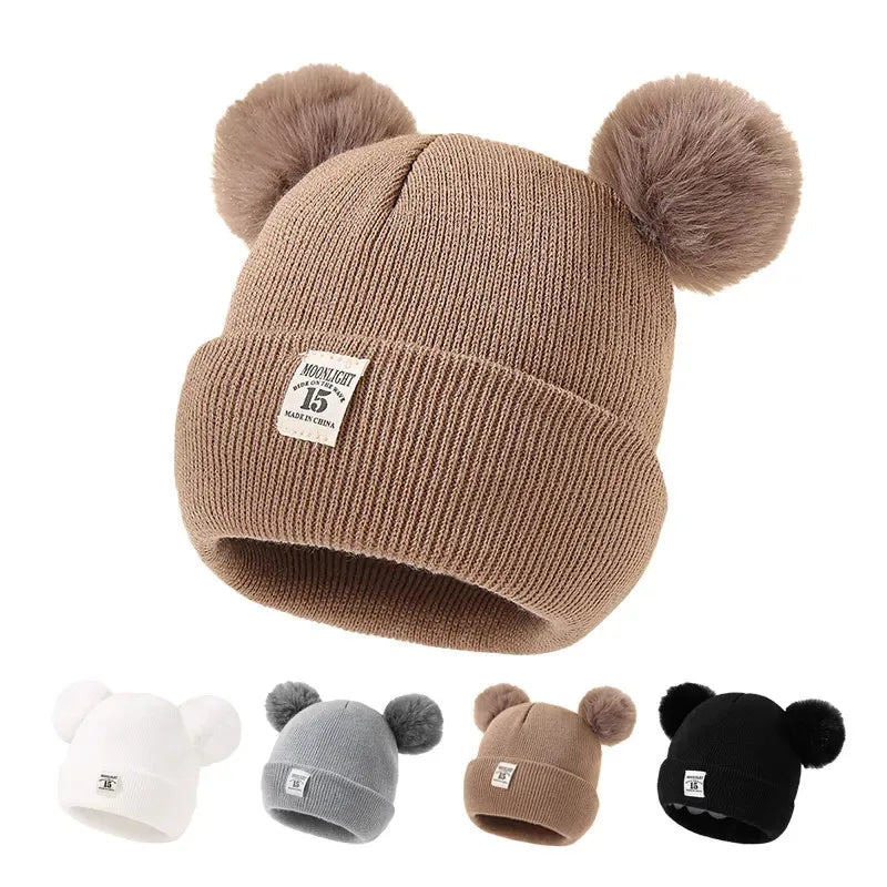 BORA kids pom pom hat in brown with cute fuzzy pom poms, perfect for winter style and warmth.