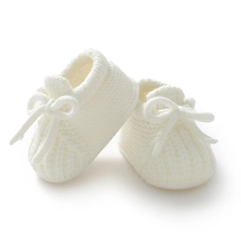 Knitted newborn baby shoes in white perfect for infant boys and girls with toddler footwear fashion style