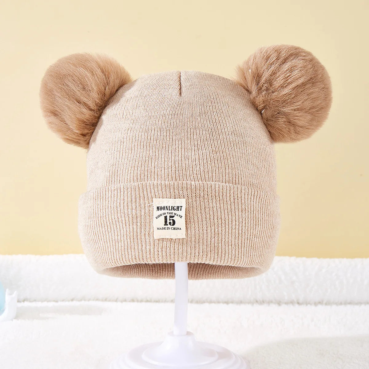 Cute BORA kids pom pom hat in beige with adorable ear-like pom poms for stylish warmth