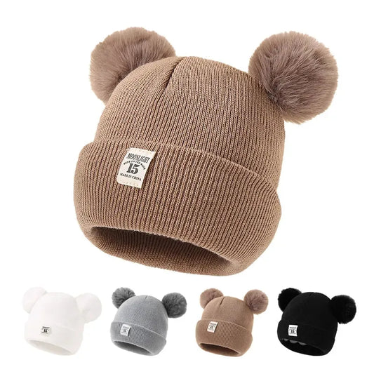 BORA kids pom pom hat in brown with cute fuzzy pom poms, perfect for winter style and warmth.